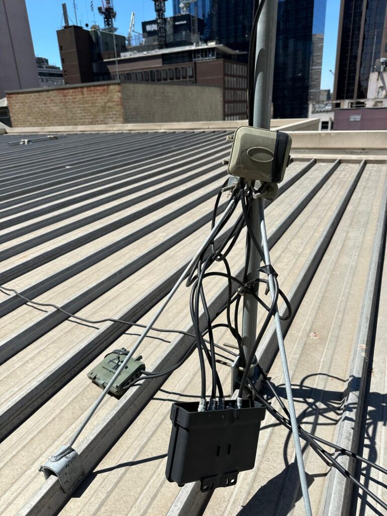 Outdoor TV antenna amplifier exposed to elements – not weatherproofed, causing interference