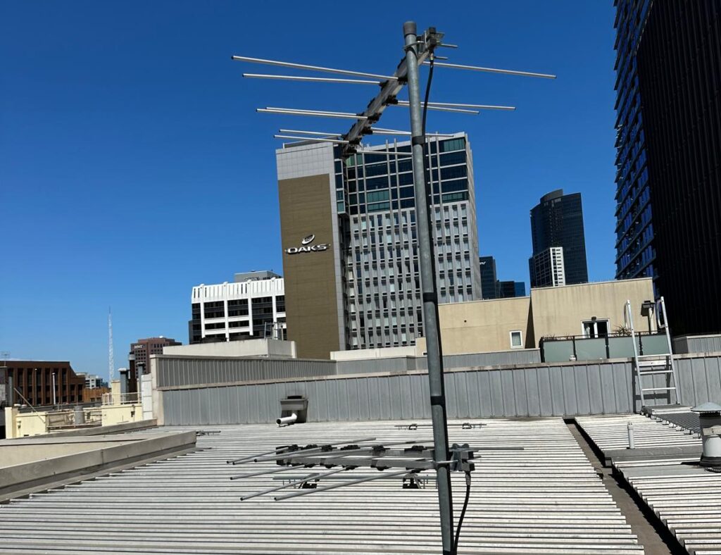 Rusty analogue TV antenna on tall commercial building roof in Melbourne CBD – digital replacement needed
